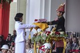     Presiden Joko Widodo (kanan) menyerahkan duplikat Sang Saka Merah Putih kepada anggota Pasukan Pengibar Bendera Pusaka (Paskibraka) saat Upacara Peringatan Detik-detik Proklamasi Kemerdekaan ke-73 di Istana Merdeka, Jakarta, Jumat (17/8/2018). HUT ke-73 RI mengambil tema Kerja Kita Prestasi Bangsa. (ANTARA FOTO/Hafidz Mubarak A)