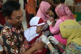 Petugas kesehatan menyuntikan vaksin Measles and Rubella (MR) kepada murit TK Islam Al Falah di Kota Kediri, Jawa Timur, Kamis (9/8). Pemerintah melalui Kementerian Kesehatan melakukan kampanye imunisasi MR lanjutan untuk anak usia sembilan bulan hingga 15 tahun tahap ke dua atas rekomendasi dari Organisasi Kesehatan Dunia (WHO). Antara jatim/Prasetia Fauzani/zk/18