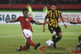 Pesepak bola Indonesia U-16 Mochammad Supriadi (kiri) berusaha melepaskan tendangan melewati hadangan pesepak bola Malaysia U-16 Mohamad IkhwanMohd Hafizd (kanan) pada laga semifinal Piala AFF U-16 di Stadion Gelora Delta Sidoarjo, Jawa Timur, Kamis (9/8/2018). Indonesia U-16 menang atas Malaysia U-16 dengan skor 1-0. (ANTARA FOTO/M Risyal Hidayat)