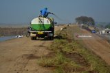 Pekerja menyiram rumput di tanggul lumpur Lapindo kawasan Jatirejo, Siring, Sidoarjo, Jawa Timur, Selasa (7/8). Kementerian Energi dan Sumber Daya Mineral (ESDM) telah memberikan izin perpanjangan kontrak kepada Lapindo Brantas Inc. untuk mengelola Wilayah Kerja (WK) Brantas di Sidoarjo, Jawa Timur periode 2020 hingga 2040. Antara jatim/Umarul Faruq/18