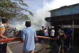 Petugas bersama warga berusaha memadamkan api yang melahap pertokoan di kawasan Pasar Gurem, Pamekasan, Jawa Timur, Jumat (10/8). Kebakaran yang diperkirakan berasal dari warung bakso yang ditingkalkan pemiliknya itu menghanguskan tiga bangunan toko. Antara jatim/Saiful Bahri/18