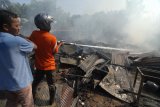 Petugas bersama warga berusaha memadamkan api yang melahap pertokoan di kawasan Pasar Gurem, Pamekasan, Jawa Timur, Jumat (10/8). Kebakaran yang diperkirakan berasal dari warung bakso yang ditingkalkan pemiliknya itu menghanguskan tiga bangunan toko. Antara jatim/Saiful Bahri/18