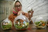 Perajin menyelesaikan pembuatan kerajinan tanaman hias Terrarium di workshop Hijau Daun, Bandung, Jawa Barat, Selasa (21/8). Workshop Hijau daun saat ini hanya menyediakan bahan baku Terrarium dengan harga Rp 35.000 - Rp.55.000 rupiah serta memberi workshop Terrarium dengan harga Rp.150.000. ANTARA JABAR/M Ibnu Chazar/agr/18.