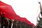 Sejumlah personel TNI membawa bendera Merah Putih berukuran besar di Jalan Raya Tegar Beriman, Cibinong, Kabupaten Bogor, Jawa Barat, Sabtu (4/8). Kirab bendera berukuran 100 meter x 5 meter tersebut merupakan rangkaian Festival Merah Putih dalam menyambut hari Kemerdekaan Indonesia ke-73. ANTARA JABAR/Yulius Satria Wijaya/agr/18.