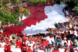 Gabungan elemen masyarakat, TNI dan Polri membawa bendera Merah Putih berukuran besar di Jalan Raya Tegar Beriman, Cibinong, Kabupaten Bogor, Jawa Barat, Sabtu (4/8/2018). Kirab bendera berukuran 100 meter x 5 meter tersebut merupakan rangkaian Festival Merah Putih dalam menyambut hari Kemerdekaan Indonesia ke-73.  ANTARA FOTO/Yulius Satria Wijaya/wsj.