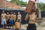 Seorang buruh mengangkat genteng dan menunjukkan ototnya saat mengikuti kontes binaraga antar Jebor (Pabrik Genteng) Jatiwangi Cup 4 di Jebor Pasaka, Majalengka, Jawa Barat, Sabtu (11/8). Kontes tahunan yang diikuti para pekerja bertubuh kekar dari sejumlah pabrik genteng di Jatiwangi tersebut digelar untuk memperingati HUT ke-73 Republik Indonesia serta rasa syukur atas melimpahnya produksi genteng tahun ini. ANTARA JABAR/Novrian Arbi/agr/18.