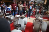 Wali Kota Kediri Abdullah Abu Bakar (kanan) mengamati motor Vespa milik peserta kontes di Gor Jayabaya Kota Kediri, Jawa Timur, Minggu (5/8). Kontes motor Vespa yang terbagi dalam 12 kategori tersebut diikuti sejumlah perwakilan klub vespa se-Indonesia. Antara Jatim/Prasetia Fauzani/zk/18