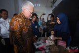 Menteri Perdagangan Enggartiasto Lukita (kedua kiri) mengamati hasil karya dari mahasiswa disela memberikan kuliah umum di Fakultas Ekonomi dan Bisnis Universitas Airlangga (Unair) Surabaya, Jawa Timur, Rabu (8/8/2018). Kuliah umum dalam rangka Dies Natalis ke-57 Fakultas Ekonomi dan Bisnis tersebut bertemakan Mendorong Kinerja Ekspor Nasional ditengah Ketidakpastian Ekonomi Global. (ANTARA FOTO/M Risyal Hidayat) 