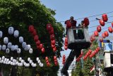 Petugas memasang lampion berwarna merah putih di depan Balai Kota Madiun, Jawa Timur, Kamis (9/8). Pemkot Madiun memasang lampion berwarna merah putih guna menyambut HUT ke-73 Proklamasi Kemerdekaan RI, 17 Agustus 2018. Antara Jatim/Siswowidodo/mas/18.