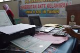 Petugas melakukan verifikasi berkas persyaratan permohonan akta kelahiran saat Pelayanan Keliling Penerbitan Akta Kelahiran Usia 0-18 Tahun di aula kantor Kelurahan Munggut, Kecamatan Wungu, Kabupaten Madiun, Jawa Timur, Selasa (28/8). Kegiatan yang digelar Dinas Kependudukan dan Pencatatan Sipil Kabupaten Madiun tersebut untuk membantu mempermudah warga mendapatkan pelayanan akta kelahiran. Antara Jatim/Siswowidodo/mas/18.