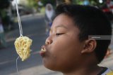 Seorang anak mengikuti lomba makan krupuk di desa Beran, Ngawi, Jawa Timur, Sabtu (11/8). Sejumlah daerah mulai menggelar lomba-lomba untuk memeriahkan HUT Kemerdekaan RI yang ke-73. Antara Jatim/Ari Bowo Sucipto/mas/18.