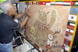 Seniman Bambang Sriyanto membuat lukisan logo dan maskot Asian Games 2018 dari cangkang telur di bengkel seninya, di Jalan Tatapakan, Bantarjati, Bogor, Jawa Barat, Selasa (7/8). Lukisan berukuran 145x81 cm yang dibuat menggunakan media limbah cangkang telur dan dikerjakan selama satu bulan tersebut merupakan bentuk apresiasi kebanggaan atas terpilihnya Indonesia sebagai tuan rumah perhelatan akbar olahraga Asian Games 2018. ANTARA JABAR/Arif Firmansyah/agr/18