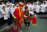 Mahasiswa asing asal Lituania yang mengikuti program pertukaran pelajar, Gabija Bargailaite (tengah) belajar Tari Remo di halaman SMP Muhammadiyah 4, Surabaya, Jawa Timur, Senin (6/8). Kegiatan yang diprakarsai oleh Association Internationale des Etudiants en Sciences Economiques et Commerciales (AIESEC) tersebut guna mengenalkan kebudayaan Indonesia serta berbagi ilmu dan pengalaman. Antara jatim/Moch Asim/18