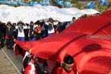 Sejumlah pemuda mengarak kain warna merah dan putih melewati jembatan lama sungai Brantas, Kota Kediri, Jawa Timur, Kamis (16/8). Kain selebar 1800m2 yang terbagi dalam sejumlah potongan tersebut akan disatukan menjadi bendera merah putih raksasa selebar 30m x 60m dan akan dikibarkan di atas pegunungan klotok guna memperingati HUT ke-73 RI. Antara Jatim/Prasetia Fauzani/mas/18.