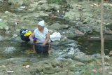 Warga mencuci pakaian menggunakan air sungai yang mulai kotor di Desa Blumbungan, Pamekasan, Jawa Timur, Jumat (10/8). Warga terpaksa memanfaatkan air sungai yang hampir tidak mengalir itu karena kesulitan mendapatkan air bersih akibat musim kemarau. Antara jatim/Saiful Bahri/18