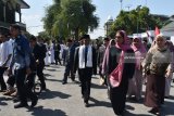 Menteri Kelautan dan Perikanan Susi Pudjiastuti (ketiga kanan) berjalan di halaman gedung pertemuan saat melakukan kunjungan ke Pondok Modern Darussalam Gontor, Ponorogo, Jawa Timur, Selasa (31/7). Kunjungan Menteri Susi Pudjiastuti ke pondok tersebut untuk bersilaturahmi dan memberikan bantuan ikan tuna sebanyak lima ton. Antara Jatim/Foto/Siswowidodo/18