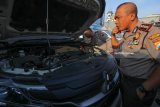 Kapolrestabes Surabaya Kombes Pol Rudi Setiawan (kanan) mengamati barang bukti mobil di Satuan Penyelenggara Administrasi SIM (Satpas) Colombo, Surabaya, Jawa Timur, Selasa (7/8). Selama 1 Januari 2018 sampai 7 Agustus 2018 Tim Khusus (Speed) Satlantas Polrestabes Surabaya mengamankan 30 unit mobil berbagai merk dan jenis yang tidak sesuai antara surat kelengkapan kendaraan dengan nomor mesin maupun nomor rangka, dan terus dilakukan penyelidikan kemungkinan adanya dugaan kejahatan curanmor (pencurian kendaraan bermotor), penggelapan, penipuan, perampasan dan pemalsuan maupun terkait fudisia dalam kasus itu. Antara Jatim/Didik Suhartono/mas/18.