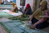 Perajin membuat pola dari daun pada selembar kain di Surabaya, Jawa Timur, Kamis (30/8). Lembaran kain yang berhias pola dari berbagai jenis daun menggunakan teknik 'eco print' itu dijual ke sejumlah daerah di Indonesia dengan harga Rp250.000 sampai Rp1.000.000 per lembar tergantung tingkat kesulitan dan ukuran kain. Antara Jatim/Didik Suhartono/mas/18.