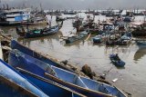 Nelayan memperbaiki tali jaring di Pantai Popoh Tulungagung, Jawa Timur, Minggu (12/8). Dua hari teakhir nelayan setempat mengaku terpaksa tidak melaut karena gelombang tinggi. Antara Jatim/Prasetia Fauzani/mas/18.