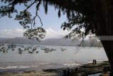 Pengunjung berada di pinggir pantai dengan latar belakang perahu nelayan di Pantai Popoh Tulungagung, Jawa Timur, Minggu (12/8). Dua hari teakhir nelayan setempat mengaku terpaksa tidak melaut karena gelombang tinggi. Antara Jatim/Prasetia Fauzani/mas/18.