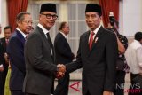     Presiden Joko Widodo (kanan) memberikan ucapan selamat kepada Menteri Sosial Agus Gumiwang Kartasasmita (kiri) seusai pelantikan di Istana Negara, Jakarta, Jumat (24/8/2018). Agus Gumiwang dilantik sebagai Menteri Sosial karena Idrus Marham mengundurkan diri seusai menerima surat penyidikan dari KPK terkait kasus suap proyek PLTU Riau-1. (ANTARA FOTO/Hafidz Mubarak A)