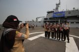 Sejumlah pelajar berfoto dengan latar belakang KRI Teluk Bintuni-520 disela-sela acara pelepasan Pelayaran Lingkar Nusantara (Pelantara) 8 dan Bakti Bela Negara 2018 di Dermaga Ujung, Koarmada II, Surabaya, Jawa Timur, Rabu (29/8). Kegiatan yang diikuti 500 mahasiswa dan pelajar dari berbagai provinsi di Indonesia bersama personel TNI Angkatan Laut tersebut merupakan ajang pembinaan yang bertujuan menumbuhkan karakter disiplin, cinta bahari dan Indonesia. Antara Jatim/Moch Asim/18