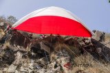 Pasukan pengibar bendera dan pemanjat tebing mengibarkan bendera Merah Putih raksasa di Gunung Batu, Lembang, Kabupaten Bandung Barat, Jawa Barat, Selasa (14/8). Kegiatan tersebut dalam rangka menyambut HUT ke-73 Republik Indonesia dan membangkitkan semangat nasionalisme pemuda. ANTARA JABAR/Pratama/agr/18