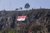 Pasukan pengibar bendera dan pemanjat tebing mengibarkan bendera Merah Putih raksasa di Gunung Batu, Lembang, Kabupaten Bandung Barat, Jawa Barat, Selasa (14/8). Kegiatan tersebut dalam rangka menyambut HUT ke-73 Republik Indonesia dan membangkitkan semangat nasionalisme pemuda. ANTARA JABAR/Pratama/agr/18