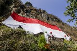 Pasukan pengibar bendera dan pemanjat tebing mengibarkan bendera Merah Putih raksasa di Gunung Batu, Lembang, Kabupaten Bandung Barat, Jawa Barat, Selasa (14/8). Kegiatan tersebut dalam rangka menyambut HUT ke-73 Republik Indonesia dan membangkitkan semangat nasionalisme pemuda. ANTARA JABAR/Pratama/agr/18