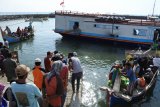 Sejumlah penumpang menaiki perahu penghubung setelah turun dari perahu layar motor di Pelabuhan Kalbut, Mangaran, Situbondo, Jawa Timur, Kamis (16/8). Puluhan penumpang dari Pulau Poday, Madura terpaksa menaiki perahu layar motor dengan hewan ternak karena belum adanya kapal atau perahu penumpang. Antara Jatim/Seno/mas/18.