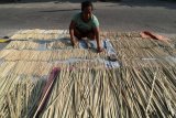 Perajin menjemur tusuk sate yang terbuat dari bambu di kampung perajin tusuk sate, Kelurahan Dadapan, Kota Kediri, Jawa Timur, Senin (20/8). Menjelang hari raya Idul Adha permintaan tusuk sate di tempat tersebut mengalami kenaikan hingga dua kali lipat dengan harga jual tetap yakni Rp14.000 per 500 batang. Antara Jatim/Prasetia Fauzani/mas/18.