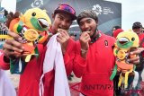 Pevoli pantai putra Indonesia Gilang Ramadhan (kanan) dan Danangsyah Yudistira Pribadi (kiri) menggigit medali perunggunya usai mengalahkan pevoli Cina pada pertandingan final perebutan medali perunggu voli pantai putra Asian Games 2018 di arena Jakabaring Sport City, Palembang, Sumsel, Selasa (28/8/2018). (ANTARA FOTO/INASGOC/Muhammad Adimaja)