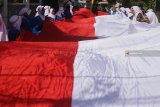 Pelajar membentangkan bendera merah putih sepanjang 73 meter dalam Peringatan HUT Kemerdekaan RI di SMK Putra Indonesia Malang, Jawa Timur, Jumat (17/8). Kegiatan tersebut juga merupakan bentuk dukungan terhadap para atlet Indonesia yang bertanding di Asian Games 2018. Antara Jatim/Ari Bowo Sucipto/mas/18.