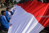 Pelajar membentangkan bendera merah putih sepanjang 73 meter dalam Peringatan HUT Kemerdekaan RI di SMK Putra Indonesia Malang, Jawa Timur, Jumat (17/8). Kegiatan tersebut juga merupakan bentuk dukungan terhadap para atlet Indonesia yang bertanding di Asian Games 2018. Antara Jatim/Ari Bowo Sucipto/mas/18.