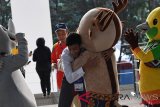 Peserta memeluk maskot Asian Games 2018 saat tiba di area Akuatik Center untuk mengikuti Upacara Pembukaan Asian Games ke-18 Tahun 2018 di Stadion Utama GBK, Jakarta, Sabtu (18/8/2018). (INASGOC/Fanny Octavianus)