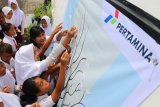 Medan (Antaranews-Sumut) - Jr Officer Comminication and Relation PT Pertamina MOR I Risky Diba Avrita (kedua kiri) membantu siswa SD Negeri 065003 meletakan kertas berisi cita-cita pada kegiatan 