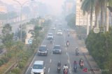 Sejumlah pengendara melintasi jalan yang diselimuti kabut asap di Pontianak, Kalbar, Senin (20/8). BNPB menyatakan bahwa hingga kini masih terpantau 526 titik api di Kalbar yang berasal dari karhutla di sejumlah kabupaten di Kalbar, yang mengakibatkan kabut asap tebal menyelimuti Kota Pontianak. ANTARA FOTO/Jessica Helena Wuysang/18