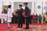 Presiden Joko Widodo (tengah) menyematkan kendit kepada anggota Pasukan Pengibar Bendera Pusaka (Paskibraka) saat pengukuhan di Istana Negara, Jakarta, Rabu (15/8/2018). Presiden mengukuhkan sebanyak 68 anggota Paskibraka yang akan bertugas pada peringatan detik-detik Proklamasi 17 Agustus mendatang. (ANTARA FOTO/Puspa Perwitasari)