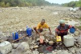 Warga membawa air dari dasar sungai Cipamingkis yang kering di Jonggol, Kabupaten Bogor, Jawa Barat, Kamis (2/8). Sebagian besar warga di wilayah tersebut memanfaatkan air dari dasar sungai Cipamingkis yang kering di musim kemarau untuk kebutuhan mencuci dan mandi. ANTARA JABAR/Arif Firmansyah/agr/18.