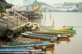 Seorang warga berjalan di atas perahu motor di Sungai Kapuas yang sedang surut di Pontianak, Kalbar, Senin (27/8). Rendahnya curah hujan selama sebulan terakhir di Kota Pontianak, menyebabkan Sungai Kapuas megalami penyurutan. ANTARA FOTO/HS Putra/jhw/18