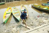 Sejumlah warga berjalan di atas perahu motor di Sungai Kapuas yang sedang surut di Pontianak, Kalbar, Senin (27/8). Rendahnya curah hujan selama sebulan terakhir di Kota Pontianak, menyebabkan Sungai Kapuas megalami penyurutan. ANTARA FOTO/HS Putra/jhw/18