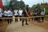 Pangdam XII Tanjungpura, Mayjen TNI Achmad Supriadi (tengah) didampingi Bupati Landak, Karolin Margret Natasa (dua kiri) memotong bambu peresmian jalan rabat beton yang dibangun dalam program TNI Manunggal Membangun Desa (TMMD) ke-102 di wilayah Kodim 1201/MPW di Desa Sempatung, Kecamatan Air Besar, Kabupaten Landak, Kalimantan Barat (8/8). Pada TMMD di Kabupaten Landak tersebut, TNI bekerjasama dengan Pemerintah Kabupaten Landak membangun jalan sepanjang 7,3 Kilometer dan lebar 6 meter. ANTARA FOTO/Sheravim/jhw/18