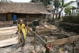Personil TNI membantu menyelesaikan renovasi rumah tidak layak huni (rutilahu) di Desa Panenjoan, Kabupaten Bandung, Jawa Barat, Rabu (1/8). Pemerintah Provinsi Jawa Barat berhasil merenovasi rutilahu sebanyak 109 ribu selama 2013 - 2017 dan menargetkan sedikitnya 30 ribu perbaikan rumah untuk tahun 2018 sebagai salah satu upaya pengentasan kemiskinan. ANTARA JABAR/Novrian Arbi/agr/18