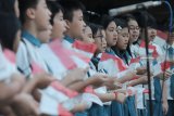 Paduan suara dari sekolah tiga bahasa Xin Zhong Surabaya menyanyikan lagu perjuangan sembari membawa bendera Merah-Putih saat mengikuti upacara bendera Hari Kemerdekaan ke-73 RI di Surabaya, Jawa Timur, Jumat (17/8). Antara Jatim/Moch Asim/18.