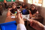 Sejumlah siswa melihat petugas kesehatan mengisi jarum suntik dengan vaksin Measles Rubella (MR) di SDN 1 Lhokseumawe, Aceh, Sabtu (4/8). Majelis Ulama Indonesia (MUI) bersepakat dengan Kementerian Kesehatan untuk menunda pemberian vaksin campak dan rubella atau MR bagi masyarakat muslim di Indonesia sambil menunggu kejelasan tentang kehalalan bahan baku pembuatan vaksin MR tersebut. (ANTARA FOTO/Rahmad/wsj/18)