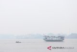 Kapal penumpang dan perahu melintasi Sungai Kapuas yang diselimuti kabut asap tebal di Pontianak, Kalimantan Barat, Sabtu (25/8). Walau hujan sudah turun di Kota Pontianak pada Jumat (24/8) kemarin, namun kabut asap pekat masih menyelimuti Kota Pontianak. ANTARA FOTO/Jessica Helena Wuysang/18