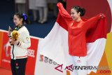 Atlet wushu Indonesia Lindswell (kanan) mengibarkan bendera merah putih saat upacara penyerahan medali emas yang diperolehnya dari nomor Taijijian Putri Wushu Asian Games 2018 di JIExpo Kemayoran, Jakarta, Senin (20/8/2018). (ANTARA FOTO/INASGOC/Akbar Nugroho Gumay)