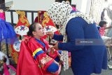 Seorang peserta Jember Fashion Carnaval (JFC) Kids defile Korea sedang dirias oleh ibunya di Kantor Pemerintah Kabupaten Jember, Jawa Timur, Kamis (9/8). Ratusan anak-anak tampil dengan mengenakan kostum 10 defile dalam Kids Carnival JFC yang melewati 