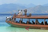 Warga mengevakuasi kuda peliharaannya ke perahu untuk diangkut ke Pulau Lombok di Gili Trawangan, Lombok Utara, NTB, Kamis (9/8). Pemilik kuda di pulau itu memilih mengevakuasi kudanya ke Pulau Lombok untuk menjaga keamanan kudanya. ANTARA FOTO/Zabur Karuru/wdy/2018.