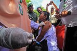 Wali Kota Lhokseumawe, Suadi Yahya (tengah) bersama Muspida menyaksikan penyuntikan vaksin Measles Rubella (MR) perdana kepada pelajar pada pelaksanaan kampanye imunisasi Campak dan Rubella (MR) di SDN-12 Lhokseumawe, Aceh, Rabu (1/8). Imunisasi program prioritas Kementerian Kesehatan tersebut bertujuan mencegah penyakit campak dan rubella guna menurunkan angka kematian anak dengan target 1,5 juta anak yang menjadi sasaran vaksin MR di Aceh. (ANTARA FOTO/Rahmad/foc/18)